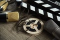 Film reel, movie clapperboard and two microphones on a table with