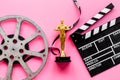 Film reel video tape with golden statue and movie clapper board Royalty Free Stock Photo