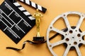 Film reel video tape with golden statue and movie clapper board Royalty Free Stock Photo