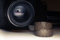 Film strips closeup with vintage movie cinema camera in shadow on background