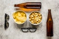 Film whatching party with beer, chips and pop corn stone background top view