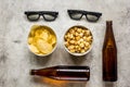 Film whatching party with beer, chips and pop corn stone background top view