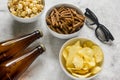 Film whatching party with beer, crumbs, chips and pop corn stone background