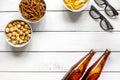 Film whatching party with beer, crumbs, chips and pop corn white wooden background top view mockup