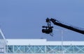 A filming camera holding by a crane