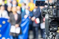 Filming political meeting or publicity event with television camera, European Union flag in background Royalty Free Stock Photo