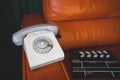 Filming some cinema movie..Vintage Brown leather armchair in loft design apartment..Old retro landline phone, sunglasses and