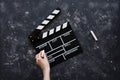 Filmmaking concept. Movie Clapperboard. Cinema begins with movie clappers. Movie clapper board on a dark background and a hand Royalty Free Stock Photo