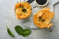 Filo pies with soft feta cheese and spinach in ceramic molds on old grey table background. Filo portions pies. Small Baked