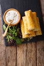 Filo rolls with meat, eggs and greens close-up and yogurt. Vertical top view