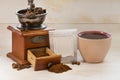 Filter bag with ground coffee, manual coffee grinder and cup of espresso coffee on a white isolated background. Copy space Royalty Free Stock Photo