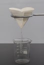 Filter paper in laboratory. Scientists are chemical filtration by filtering through filter paper in a glass funnel, Close up