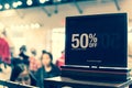 Filtered image 50 percent off sale sign over clothes at department store with customer shopping