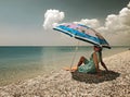 Filtered view of a girl, umbrella and beach