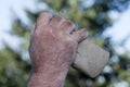 Filthy hand holding handaxe Royalty Free Stock Photo