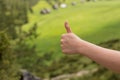 Fimale traveler showing thumb up against the backdrop of nature. Tourism concept. Copyspace