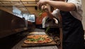 Final Touches: Chef Adding Fresh Arugula to Gourmet Pizza