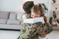 Finally meet each other. Soldier in uniform is at home with his little daughter