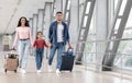 Finally Vacation. Excited Smiling Arabic Family Holding Hands While Walking At Airport Royalty Free Stock Photo