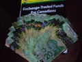 Finance book with canadian money on top. Personal finance and canadian dollars recession help