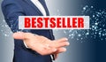 A businessman holds his hand, palm up, above the palm the inscription - BESTSELLER