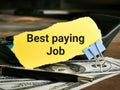 Phrase Best paying job written on yellow torn paper with calculator,pen and fake money. Royalty Free Stock Photo