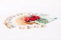 Finance and car loan, saving money for a car or material design concepts. Red car on euro banknotes. Money for car loan payment on