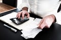 Man at desk with calculator, bills or sales slips and notpad