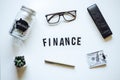 Finance Courses Online. Budget Planner. Word Finance, laptop, mason jar saving bank, stationery and glasses on table