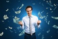 Finance freedom, money, wealth and success concept with powerful and happy man on blue background under dollar banknotes rain