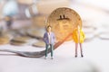 Finance investment risk Internet concept: Miniature business standing near Bitcoin Digital Virtual money with hard fork and stack Royalty Free Stock Photo