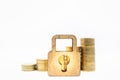 Finance, Money, Security and Saving Concept. Close up of wooden master key lock icon in front of stack of gold coins on white Royalty Free Stock Photo