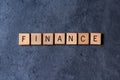 `Finance` spelled out in wooden letter tiles