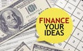 FINANCE YOUR IDEAS words on yellow sticker with dollars and charts