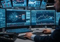 A financial analyst is working in front of multiple computer monitors displaying complex data Royalty Free Stock Photo