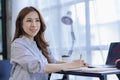 Financial concept of ambitious asian business woman working from home looking at laptop screen and smiling. Woman checking mail
