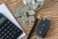 Financial concept as car key with stack of coin, pencil note boo