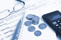 Financial concept. Close-up coins, pen, calculator and glasses at financial report. Royalty Free Stock Photo
