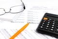 Financial concept. Close-up pen, calculator and glasses at financial report. Royalty Free Stock Photo