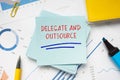 Financial concept about DELEGATE AND OUTSOURCE with sign on the piece of paper