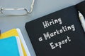 Financial concept about Hiring a Marketing Expert with inscription on the piece of paper