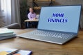 Financial concept meaning HOME FINANCES with sign on the data processor. Accountant working at work table