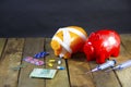 Financial concept showing an injured piggy bank with medicine tablets, syringes, little money