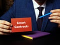 Financial concept about Smart Contracts with sign on red business card in hand