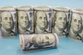 Stack of rolled up dollar bills on blue background Royalty Free Stock Photo