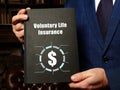 Financial concept about Voluntary Life Insurance with sign on the black notepad