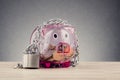 Piggy bank surrounded by chains and padlock on wooden desk