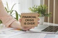 FINANCIAL CRISIS IS OVER, business concept. text on notebook paper in hand Royalty Free Stock Photo