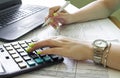 Financial data analyzing. Counting on calculator and laptop. Hand with pen on financial table Royalty Free Stock Photo