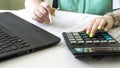 Financial data analyzing. Counting on calculator and laptop. Hand with pen on financial table Royalty Free Stock Photo